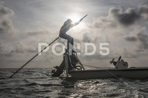 Caucasian fisherman rowing boat on ocean Stock Photos