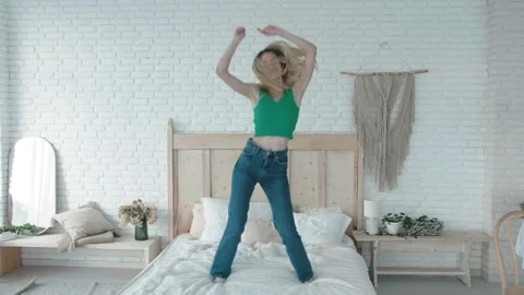 Woman with vitiligo holding pillow between legs on bed in front of