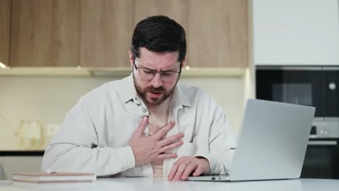 Caucasian freelancer with weak heart using wireless pc while sitting by desk Stock Footage 266895176