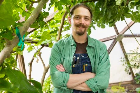 Caucasian gardener smiling in greenhouse 库存照片