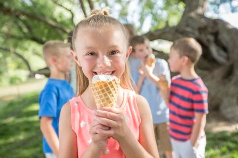 Caucasian girl eating ice cream cone Stock Photos