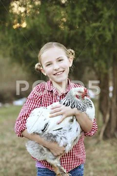 Caucasian girl holding chicken on farm Stock Photos
