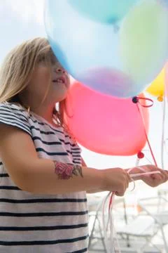 Caucasian girl holding multicolor balloons Stock Photos