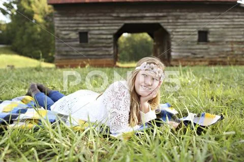 Caucasian girl laying in grass on farm Stock Photos