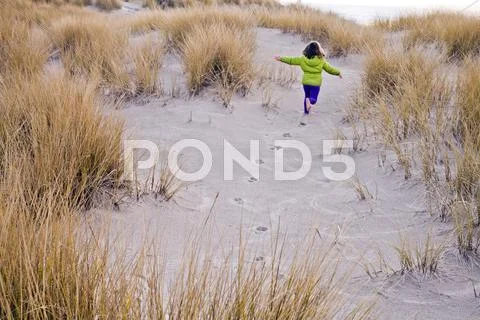 Caucasian Girl Running On Sand Dunes