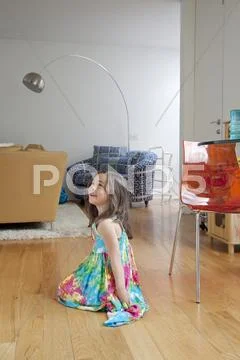 Caucasian girl sitting on living room floor Stock-Fotos