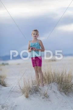 Caucasian Girl Standing On Sand Dune