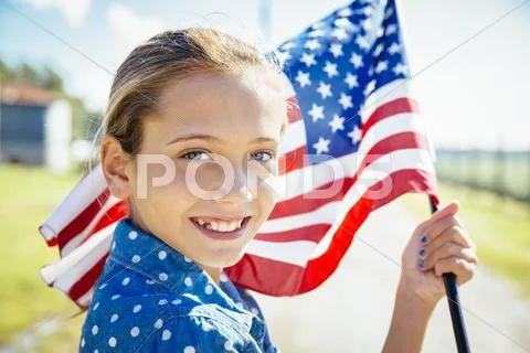 Caucasian Girl Waving American Flag On Farm