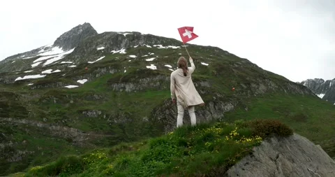 Caucasian girl waving the Swiss national flag with her back to the camera Stock Footage