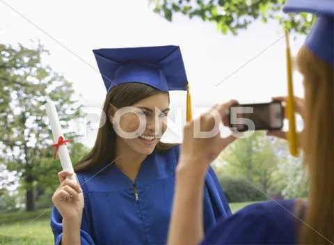 Caucasian graduating teenagers taking photographs Stock Photos