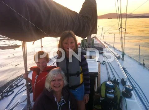 Caucasian grandmother and grandchildren on sailboat Stock Photos