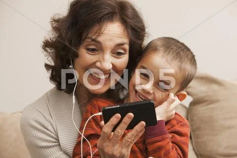 Caucasian Grandmother And Grandson Listening To Mp3 Player