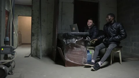 Caucasian guy and black guy are hidin in a basement during a war Stock-Footage 171348602