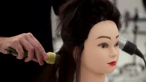 Caucasian guy in black clothes cuts the mannequin's hair Stock Footage 164060073