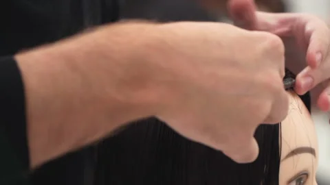 Caucasian guy in black clothes cuts the mannequin's hair 스톡 동영상 164179968