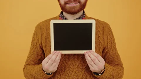 Caucasian guy with ginger beard showing blank tablet screen to the camera and Stock Footage 171837639