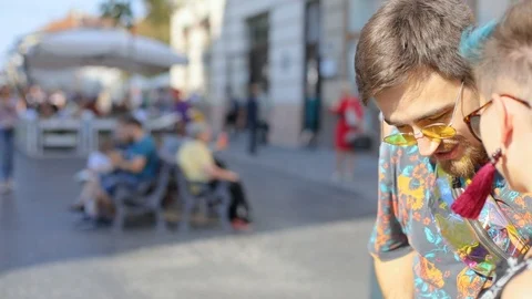 Caucasian guy in glasses shows something in his smartphone girl in glasses and Video stock 100731467