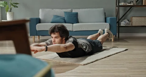 Caucasian guy keeping himself fit during lockdown. Sporty guy is doing exercises Stock Footage 137464337