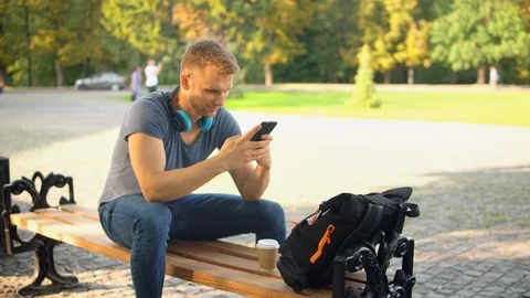 Caucasian guy messaging text on mobile at the open air Stock Footage 117419608