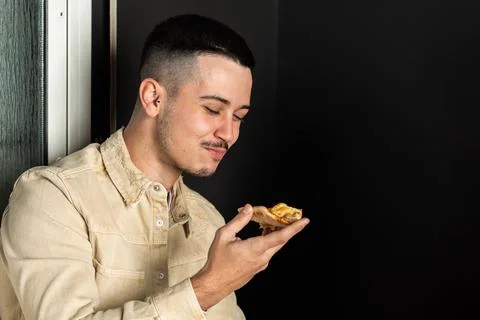 Caucasian guy with mustache eats a slice of pizza Stock Photos