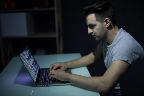 Caucasian hacker hacking the server in the dark Foto stock