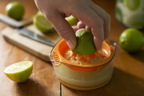 Caucasian hand squeeze lime using manual juicer Stock Photos