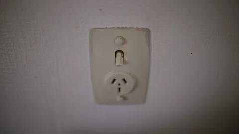 Caucasian hand unplugging white plug then turning off power point switch Stock Footage 227289732