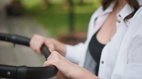 Caucasian hands adjust stroller handle. Steady grip on stroller handlebar Video stock 346382767