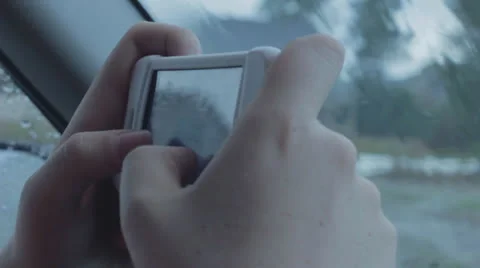 Caucasian Hands Texting on iPhone in Car on Rainy Day Stock Footage
