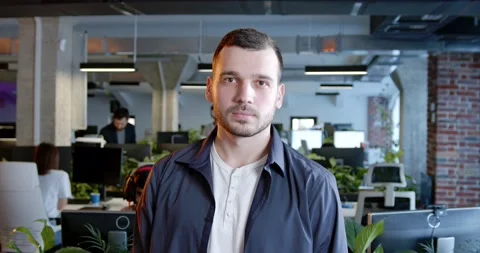 Caucasian handsome man looking at camera in office. Indoors. Portrait of young Stock Footage 180051244