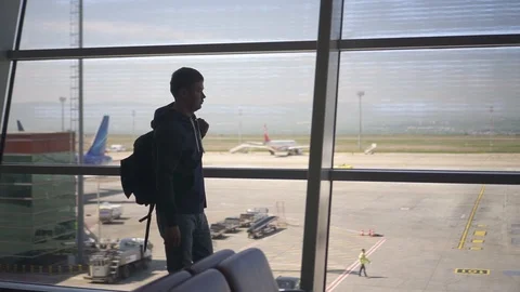 Caucasian handsome man walking through airport corridor, carrying suitcase. Stock Footage 119892012