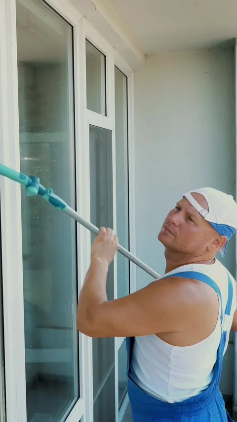 Caucasian handsome man, worker of cleaning service, in blue overalls and in a Stock Footage 317165760