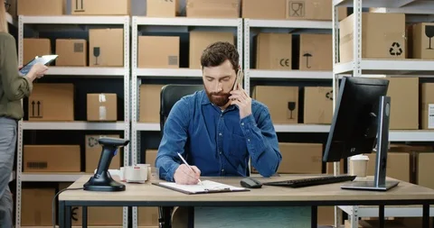 Caucasian handsome man working at computer in post office store of parcels and Stock Footage 125219129
