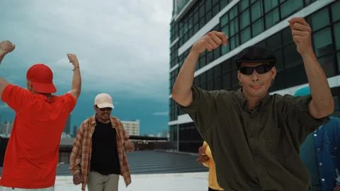 Caucasian hipster walking while dancing together at rooftop with city. Endeavor. 库存照片