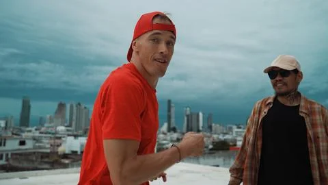 Caucasian hipster walking while dancing together at rooftop with city. Endeavor. 写真素材