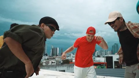 Caucasian hipster walking while dancing together at rooftop with city. Hiphop. 写真素材