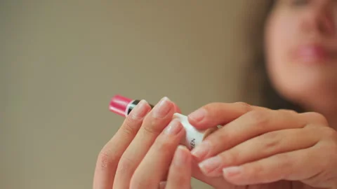 Caucasian influencer in hotel vanity selecting lipstick, confident evening prep Stock Footage 345137012
