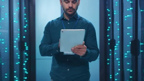 Caucasian IT engineer activating digital database server room with tablet Stock Footage 119842341