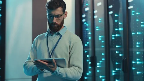 Caucasian IT engineer working on digital tablet collecting network data on rack Stock Footage 119233600