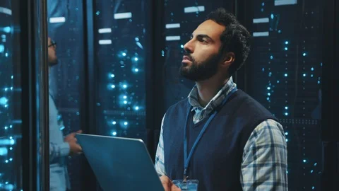 Caucasian IT technician webhosting in digital server room looking into data Stock Footage 119278684