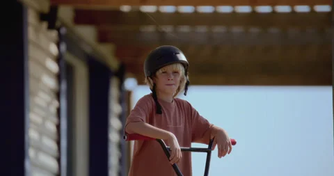 Caucasian kid boy posing with his bicycle on a porch of family house Stock Footage 252564405
