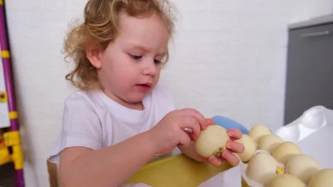 Caucasian kid decorating Easter eggs with a sticker, preparing for the spri.. Stock-Footage 330109047