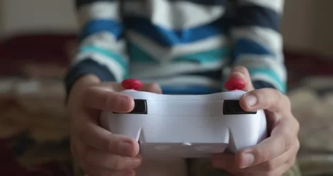 Caucasian kid hands use joystick remote controller. Boy play video game. 4K Stock Footage 345220734