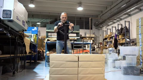 Caucasian labor working class using a manual pallet truck for moving big 動画素材 263541373