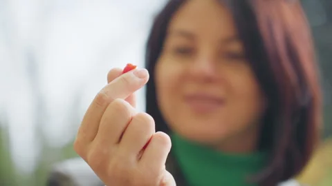 Caucasian lady displaying tiny scarlet berry, Closeup of woman with small red Stock Footage 329580679