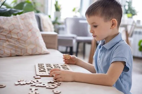 A Caucasian light-haired boy of five years old with blue eyes is putting Stock Photos