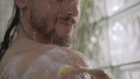 Caucasian long haired man cleaning her skin sponge relaxing in shower from Stock Footage 248865952