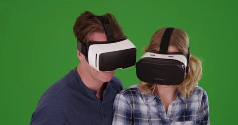 Caucasian male and female wearing smartphone VR headset on green screen Stock Footage