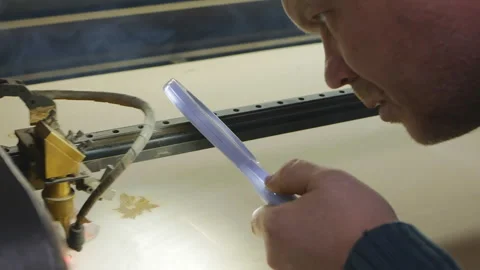 Caucasian male design engineer testing the laser head on a laser engraving and Stock Footage 143625267
