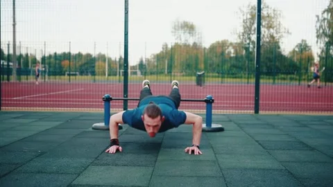 Caucasian man actively doing push-ups, exercising on the outdoor Stock Footage 149749992